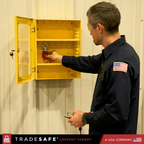 Man using a Lockout Tagout Cabinet For Unfilled Station Wall Mountable LOTO Box Industrial Grade 19 Gauge Steel With Durable Shackle Holders No Devices Included Heavy Duty Lockout Center For Safe Equipment Lockouts mounted on a wall.