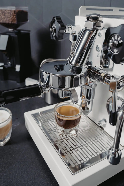Next Level Home Bar Essentials Italian Handcrafted Espresso Machine With Heat Exchanger And E61 Manual Controls Badass Stainless Steel Chassis Three Liter Tank Fresh White Finish close-up of espresso brewing with stainless steel components.