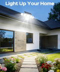 Solar Flood Lights Outdoor 6000LM 336 LEDs illuminating a house exterior and garden pathway at night.