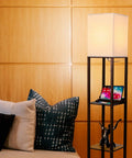 Maxwell Charger Shelf Floor Lamp With USB Ports And Electrical Outlet in a living room, showcasing Havana Brown finish and LED light