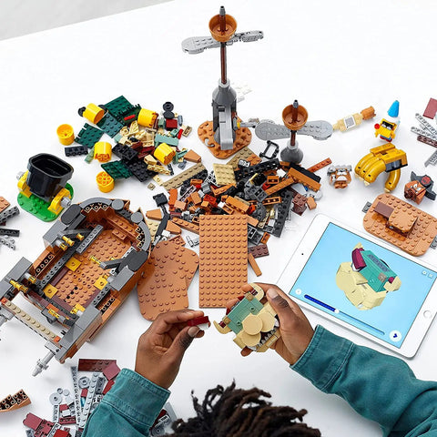 Hands assembling Super Mario Bowser’s Airship Expansion Set 71391 Epic Buildable Play Toy with 1,152 pieces on a table with tablet guide.