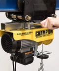 Heavy Duty Electric Hoist With Remote Control And Automatic Braking 850 Watt Motor 39 Foot Cable Dual Line Operation 440 And 880 Lb Lifting Capacity Ideal For Garages And Workshops in use
