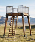Four Piece Trail Tough Heavy Duty Steel Deer Stand Brackets For 4x4 Posts Rock Solid Hunting Setup Reinforced Bearing Supports Heavy Load Capacity Camp Accessories mounted on an elevated wooden platform.