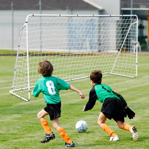 Two kids playing soccer in front of a Backyard Soccer Goal 12 By 6 With Steel Frame Portable Training Net For Kids And Adults Waterproof Ground Stakes Carry Bag Easy Setup For Shooting Practice And Family Fun on grass field.
