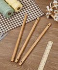 Six Top Shelf Wooden Dowel Rods With Dual Center Holes 11 8 Inch Solid Hardwood Sticks on a wooden surface with fabric and tools.