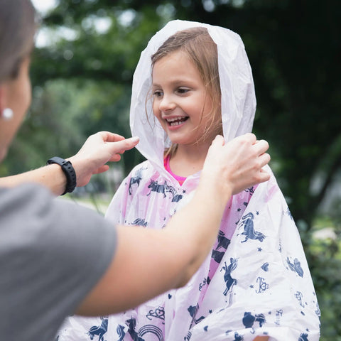 Child wearing a Disposable Rain Ponchos Family Pack Eight Pack With Hood For Adults And Kids Waterproof Emergency Travel Ponchos