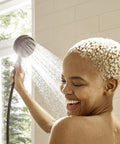 Woman enjoying shower with Pulsify S Handheld Shower Head Set Matte Black Finish With Three Spray Modes Including PowderRain