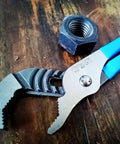 V Jaw Tongue And Groove Pliers Set With Dipped Handles, close-up of open pliers on wood, showing blue handles and metal teeth