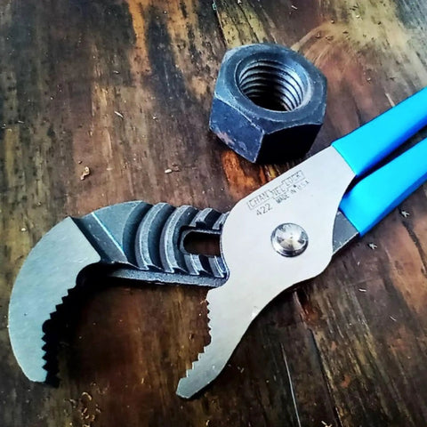 V Jaw Tongue And Groove Pliers Set With Dipped Handles, close-up of open pliers on wood, showing blue handles and metal teeth
