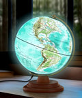 Lit 8 Inch Illuminated World Globe With Wooden Stand Built In LED Night Light Turquoise Blue Globe For Kids And Adults Learn Geography At Home Office Or Classroom Decor Educational Gift on a desk.