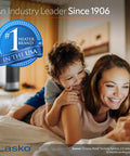 Mother and child smiling while using phone with Compact Ceramic Space Heater CD09250 in the background