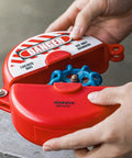 Person installing Red ABS Gate Valve Lockout With Padlock For Two Point Five To Five Inch Handles, OSHA compliant, in use view.