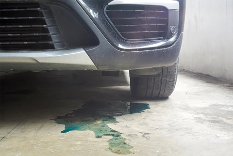 Car with fluid leak on concrete floor, highlighting need for Instant Gas Tank And Radiator Repair Epoxy Putty That Grips Wet Surfaces.
