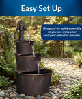 40 Inch Rustic Tiered Barrel Water Fountain For Outdoors with old-fashioned pump, three barrel tiers, in garden setting.