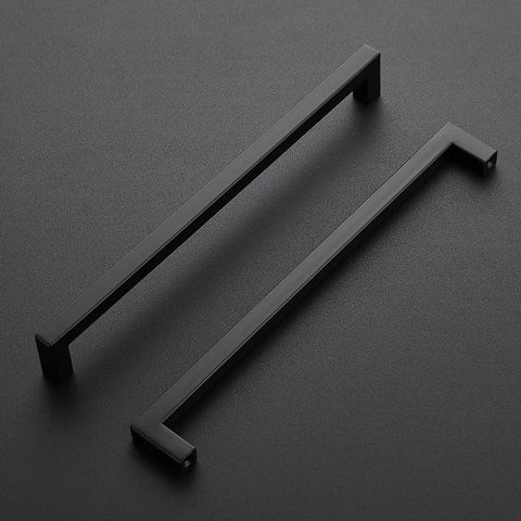 Two matte black square kitchen drawer handles resting on a dark surface, part of a Five Pack Matte Black 10 Inch Cabinet Pulls Square Kitchen Drawer Handles With Screws And Included Screwdriver Durable Hardware For Cabinets And Drawers Easy Install For Modern Kitchens.