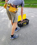 Person wearing 11 Pocket Suede Leather Heavy Duty Tool Belt Built Tough For Pros with hammer loops and measuring tape, adjusting toolbox