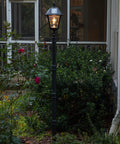 Solar Lamp Post Kit 77 Inch Outdoor Light With Black Resin Post Clear Lens EZ Anchor Ground Auger in garden setting.