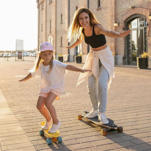 A child and an adult skateboarding outdoors, highlighting the Skateboard Bushing Kit 10 Pack 90A PU Longboard Truck Bushing Rebuild Set.