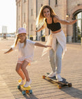 Mother and daughter skateboarding on a sunny street
