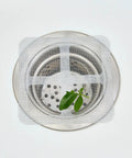 10 Piece Pack Disposable Shower Drain Catcher 3.9 Inch Silver Mesh Filter For Tub And Sink placed over a stainless drain.