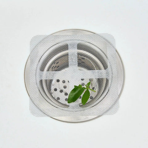 10 Piece Pack Disposable Shower Drain Catcher 3.9 Inch Silver Mesh Filter For Tub And Sink placed over a stainless drain.