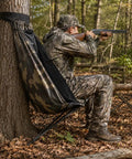Hunter using Low Profile Hunting Chair Hammock Seat With 360 Degree Swivel Portable Camouflage Ground Stool for deer in the woods