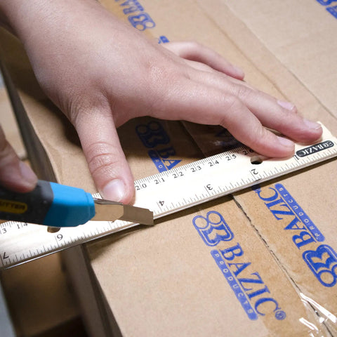 12 Inch Wooden Ruler With Inch And Metric Measurements Dual Scale being used to cut cardboard for precise lines.