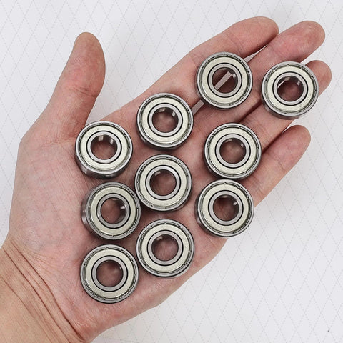 Heavy duty ball bearings 6205 ZZ in hand, set of 10, showcasing double metal shielded design for machinery and automotive use.