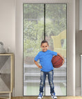 Boy holding basketball stands in doorway with Heavy Duty Magnetic Screen Door With Micro Mesh For Easy Hands Free Entry And Exit No Fuss