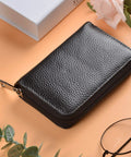 Genuine Leather Card Holder With Zipper Wallet For 26 Cards Black Slim And Durable Compact on beige surface with glasses