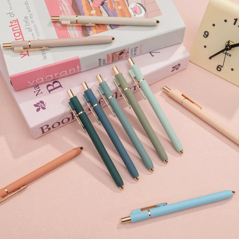Colorful gel pens with metal gold clips on books and pink surface, alternative to Black Gel Pens 0.5mm Fine Point Retractable.