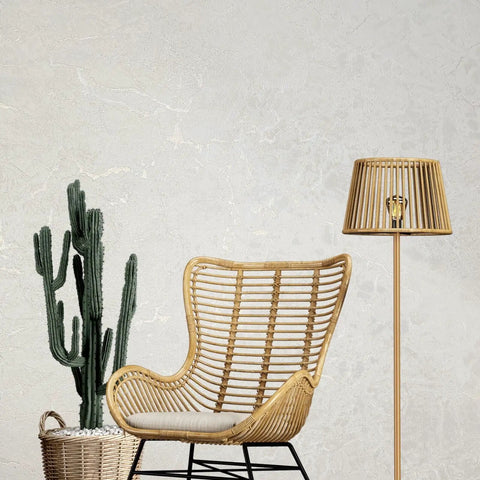 Ivory And Off White Rose Gold Cracked Faux Concrete Plaster Textured Wallpaper Rolls Chic Home Decor Peel And Stick Removable Wall Covering DIY Project in modern living space with rattan chair and floor lamp.