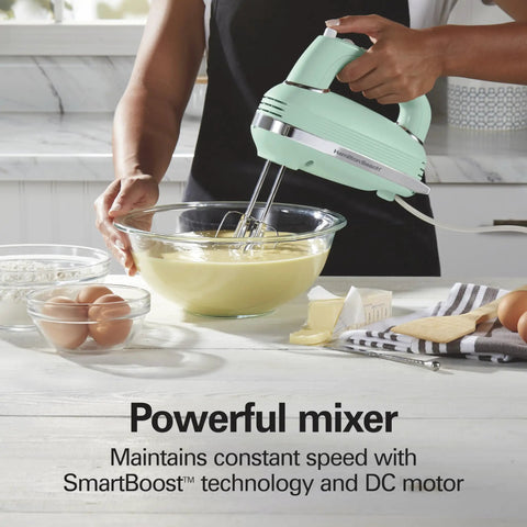 Retro 5 Speed Electric Hand Mixer With SmartBoost Tech And Powerful Dc Motor Designed For Effortless Mixing Whipping Dough and Creating Delicious Homemade Desserts This Slick Kitchen Gadget Rocks Smooth Operation For All Your Baking Needs, in mint green, mixing batter in a glass bowl.