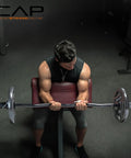 Man using 47 Inch Olympic EZ Curl Bar From Classic Series Black With Angled Ergonomic Design in home gym for arm curls