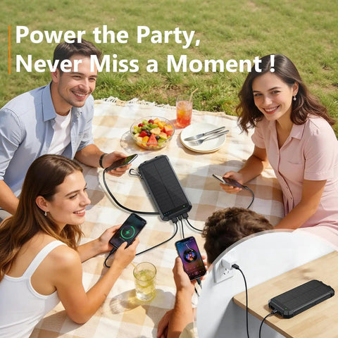 People using 20000mAh Solar Power Bank With Wireless Charging Built In Cables And 15W USB C Fast Charging Charge Up To Six Devices At Once Compatible With iPhone And Samsung Emergency LED Flashlight Ideal For Camping And Hiking outdoors on a picnic table.