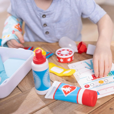 Child playing with Get Well First Aid Kit Play Set For Kids With 25 Realistic Medical Tools, including bandages and splint.