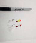 Two shad darts fishing lures with bucktail next to a Sharpie for scale, part of the Shad Darts Fishing Lures Kit 25 Pack With One Eighth Oz Jig Heads And Bucktail Assorted 5 Colors Perfect For Crappie American Shad Bass Walleye Panfish Realistic Swimming Action And Bright Paint.