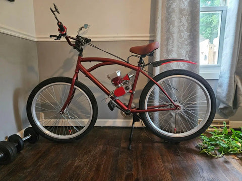 Red bike with motor, featuring large wheels indoors, used with Beefy 26 Inch Bike Rim Wheel Set Built Tough With Double Wall Aluminum Alloy.