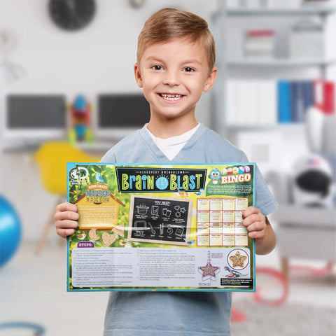 Child holding Brain Blast educational kit with colorful packaging in a playroom setting.