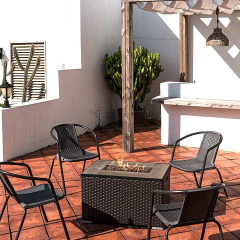 Outdoor patio with propane fire pit, surrounded by chairs, showcasing Copper Reflective Fire Glass 10 Lbs with multicolor shine.