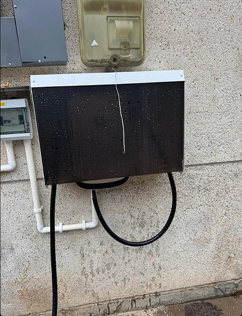 Heavy Duty Outdoor Ev Charger Rain Cover Featuring Galvanized Steel Construction And Wall Mount Spacing For Nasty Weather And Hella Tough Type Two Housing on wall with water droplets.