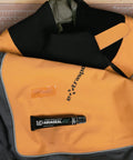 Aquaseal FD Flexible Durable Repair Adhesive 0.75 oz tube beside orange and black wetsuit on cutting mat