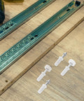 Heavy Duty 4 Piece Bi Fold Closet Door Hardware Kit With Top Roller Pivot Set In Modern White Finish Built For Super Smooth Glide And Rock Solid Performance On Interior Folding Doors Great For Quick Repairs And Maintaining Awesome Door Style Day, white hardware laid on wood