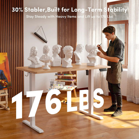 CubiCubi Large Electric Height Adjustable Standing Desk Maple Surface with artist working, showcasing stability and design.