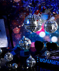 Various sizes of 30 Pcs Mini Disco Ball Ornaments Hanging Mirror Balls For Party Decor Wedding on dark reflective surface