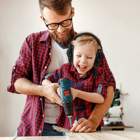 Child wearing 3 Pack Kids Noise Reduction Headphones For Ear Protection Earmuffs 27dB while using a drill with an adult.