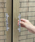 Hand holding rustic twig drawer pulls with metal branch cabinet handles and screws for kitchen dresser wardrobe furniture hardware.