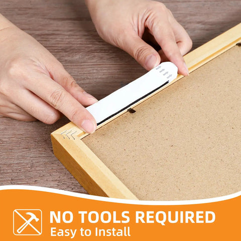 Hands applying Heavy Duty Picture Hanging Strips Set With 56 Strips For Damage Free Walls No Nails to frame back
