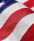 Close-up of Heavy Duty 5x8 Ft US Flag With Embroidered Stars And Sewn Stripes, Nylon Construction, showing water droplets on stripes.