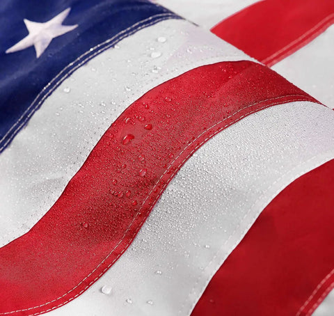 Close-up of Heavy Duty 5x8 Ft US Flag With Embroidered Stars And Sewn Stripes, Nylon Construction, showing water droplets on stripes.
